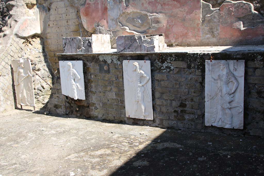 Herculaneum, April 2014. Sacred Area terrace, looking north in the shrine of the Four Gods.
The copies of the reliefs are thought to be hanging in their original position, fastened to the front wall of the podium.
Photo courtesy of Klaus Heese.